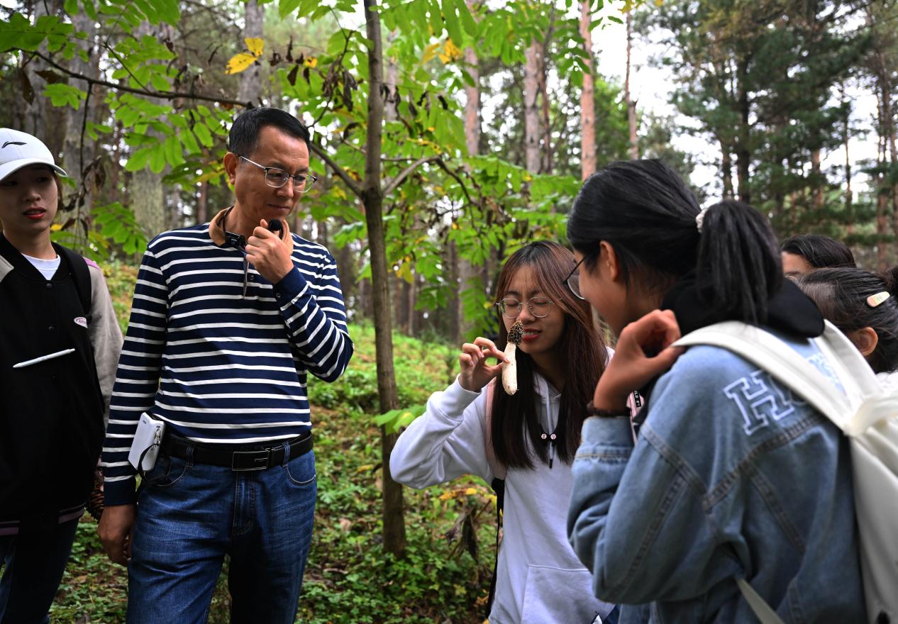 王占斌老師給同學們講解辨識蘑菇。（學校供圖）.jpg