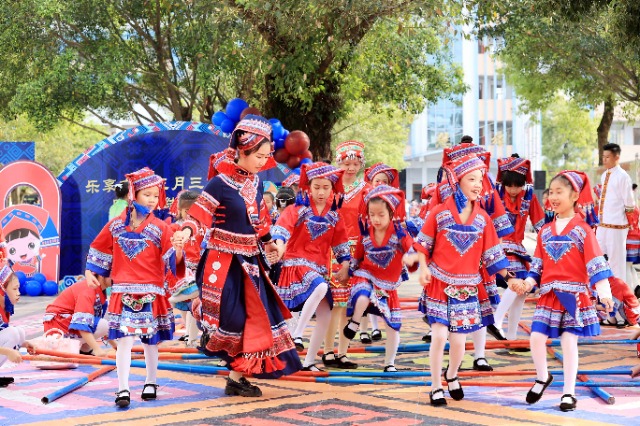 圖4：4月9日，在廣西柳州市融安縣實(shí)驗(yàn)小學(xué)校園，一名老師帶著學(xué)生跳竹竿舞。（譚凱興 攝）.JPG